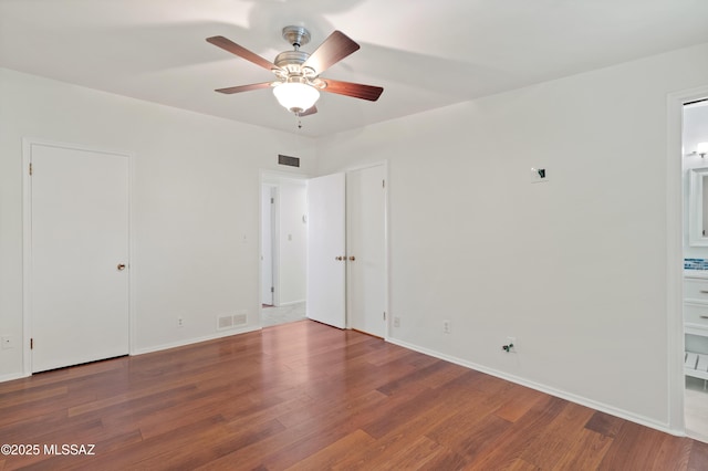 empty room with visible vents, baseboards, and wood finished floors