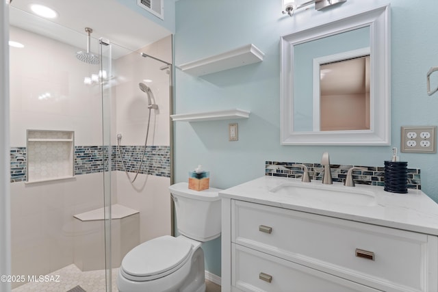 bathroom with visible vents, a shower stall, vanity, and toilet