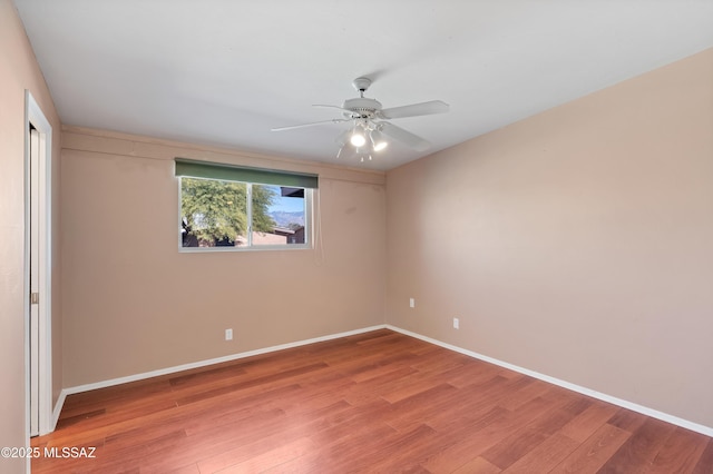 unfurnished room featuring wood finished floors, baseboards, and ceiling fan