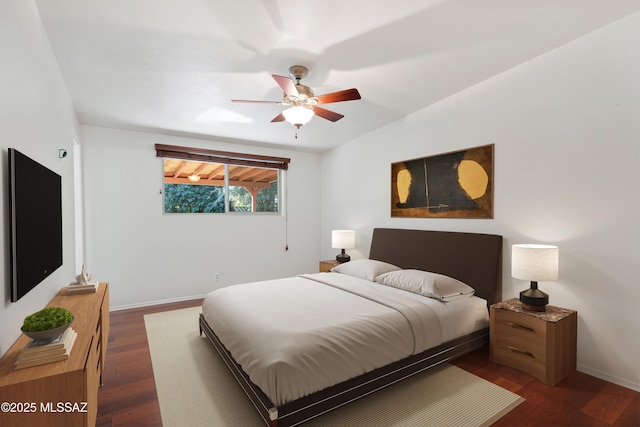 bedroom with ceiling fan, baseboards, and dark wood finished floors