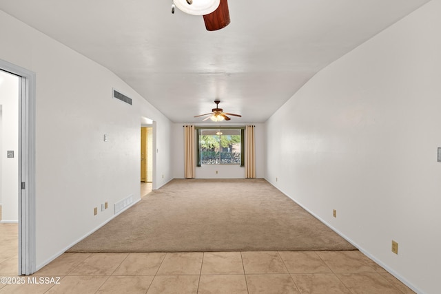 unfurnished living room with ceiling fan, light colored carpet, and lofted ceiling