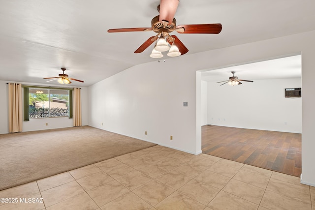 empty room featuring light colored carpet, light tile patterned flooring, and vaulted ceiling