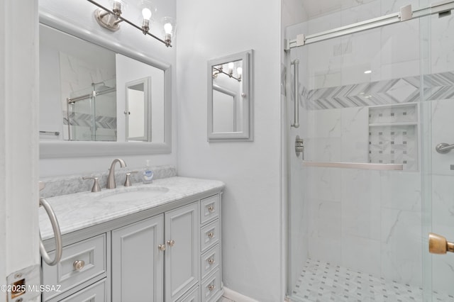 full bathroom featuring a marble finish shower and vanity