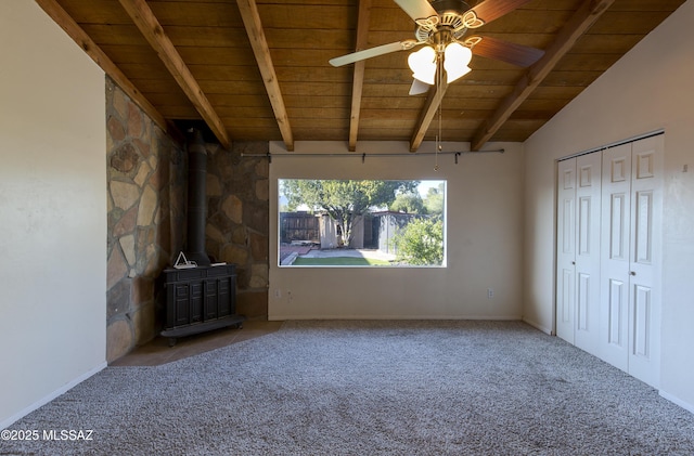 unfurnished living room with a wood stove, ceiling fan, wooden ceiling, vaulted ceiling with beams, and carpet