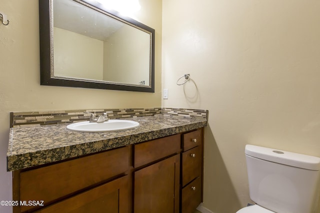 bathroom featuring decorative backsplash, vanity, and toilet