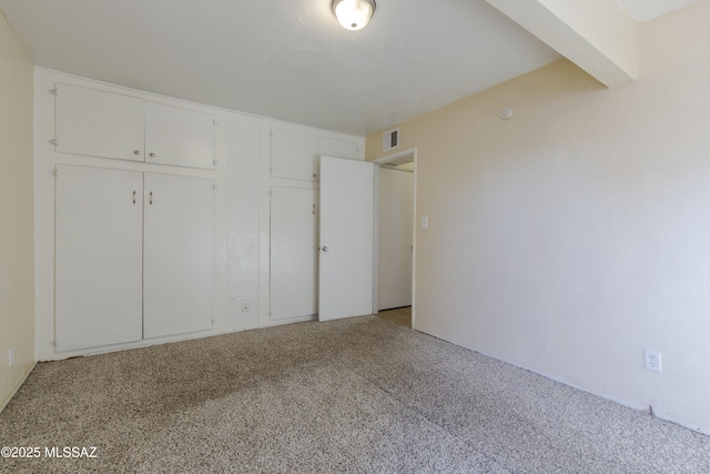 unfurnished bedroom featuring light colored carpet and a closet