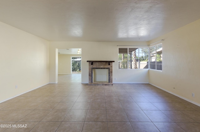 unfurnished living room with a fireplace, plenty of natural light, and light tile patterned floors