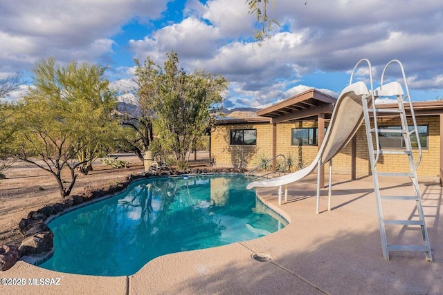 view of pool with a patio area and a water slide