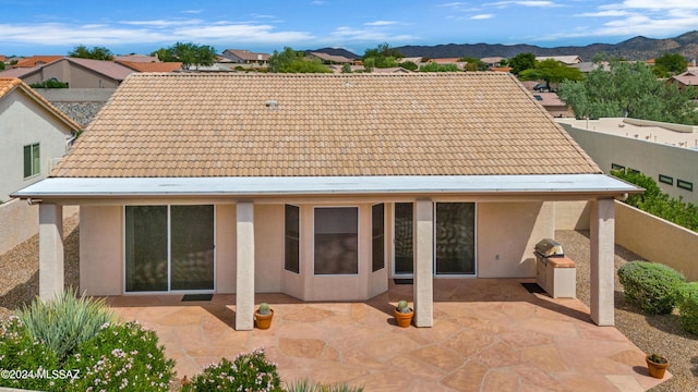 rear view of house featuring a mountain view and a patio