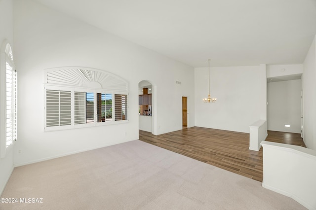 unfurnished room with light carpet, a healthy amount of sunlight, and an inviting chandelier