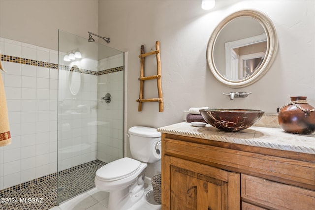 bathroom featuring tiled shower, tile patterned floors, vanity, and toilet