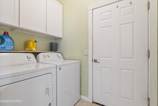 washroom with cabinets, washer and clothes dryer, and light tile patterned flooring