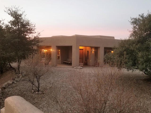 back house at dusk with a patio area