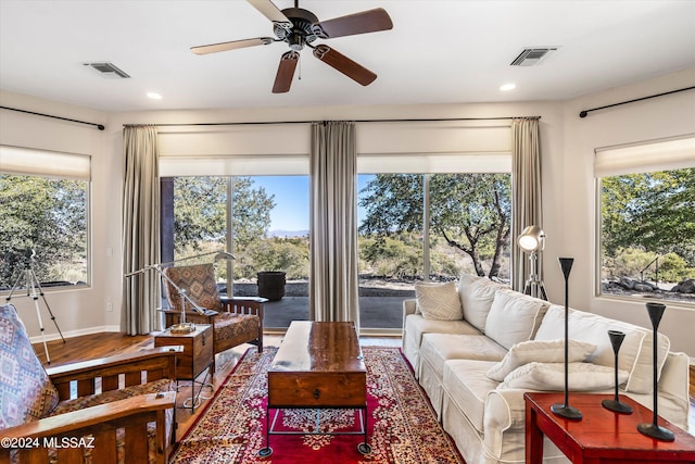 living room featuring ceiling fan, plenty of natural light, and wood-type flooring