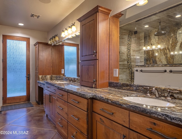 bathroom featuring tile patterned flooring, walk in shower, and vanity