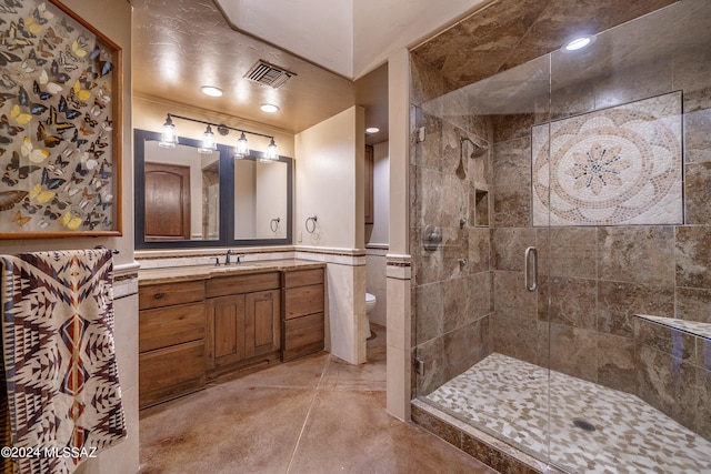 bathroom with tile walls, toilet, vanity, and an enclosed shower