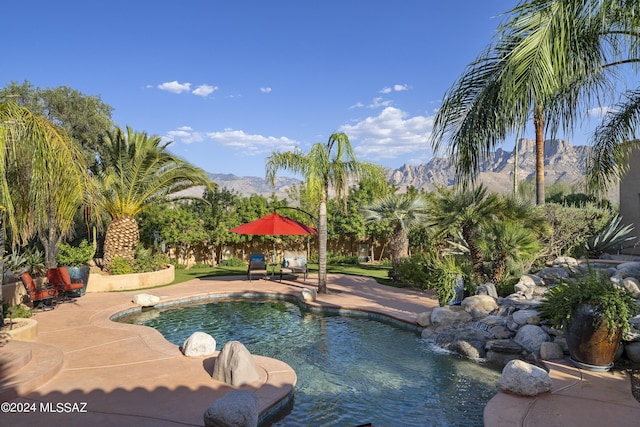 view of swimming pool featuring a patio area and a mountain view