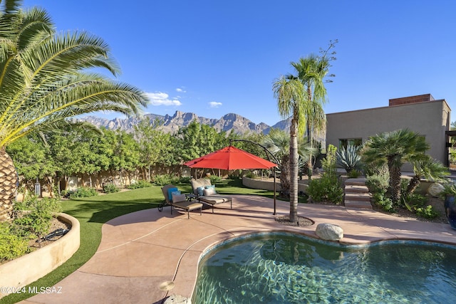 view of swimming pool featuring a mountain view, a lawn, and a patio