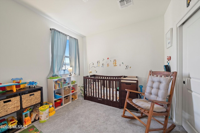 bedroom featuring carpet, visible vents, and a crib