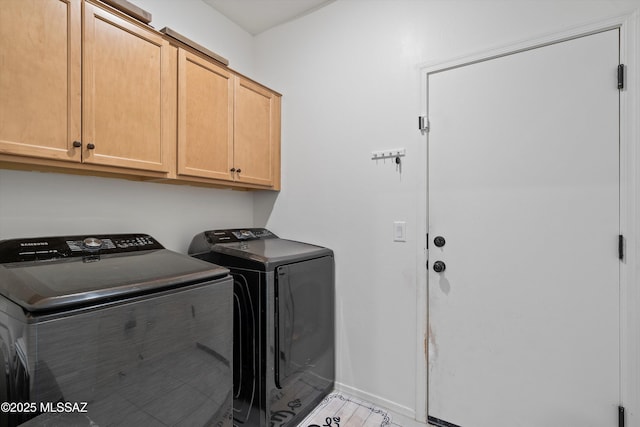washroom with baseboards, cabinet space, and independent washer and dryer