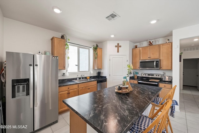 kitchen with visible vents, a sink, stainless steel appliances, and light tile patterned floors