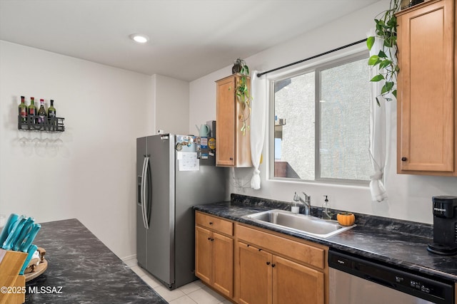 kitchen featuring dark countertops, a sink, light tile patterned floors, appliances with stainless steel finishes, and recessed lighting