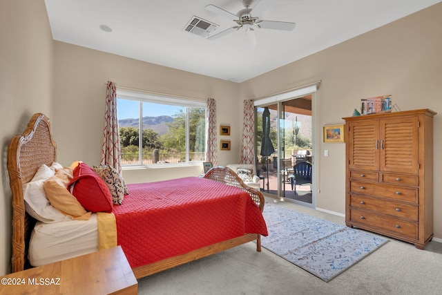 carpeted bedroom with ceiling fan, a mountain view, and access to outside