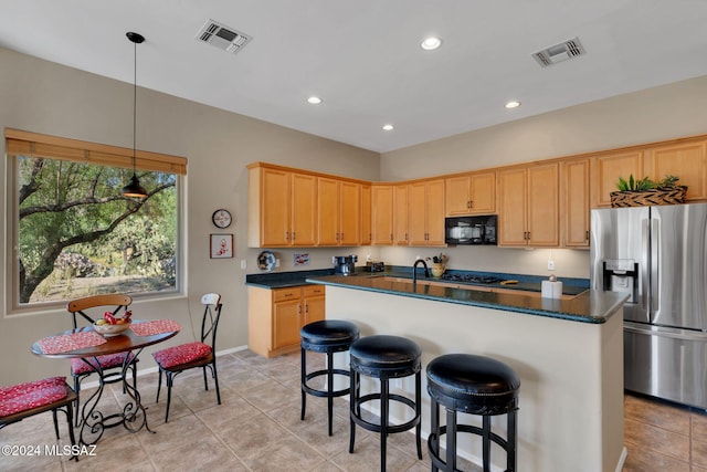 kitchen featuring hanging light fixtures, light tile patterned flooring, stainless steel refrigerator with ice dispenser, and a kitchen island with sink