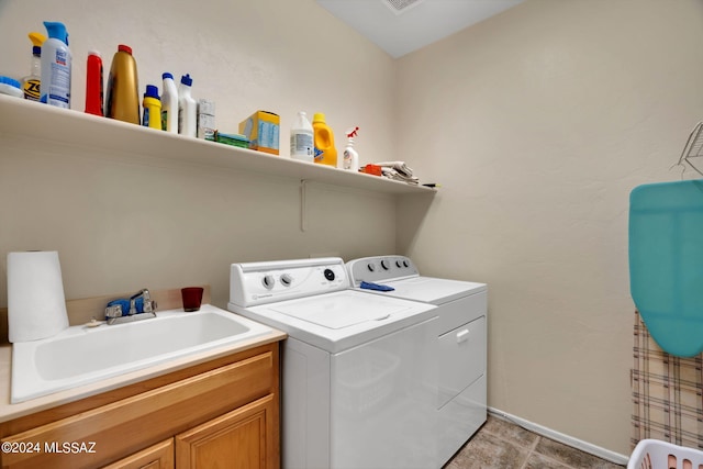 laundry room featuring cabinets, separate washer and dryer, and sink