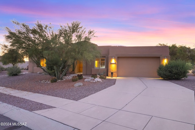 pueblo revival-style home featuring a garage