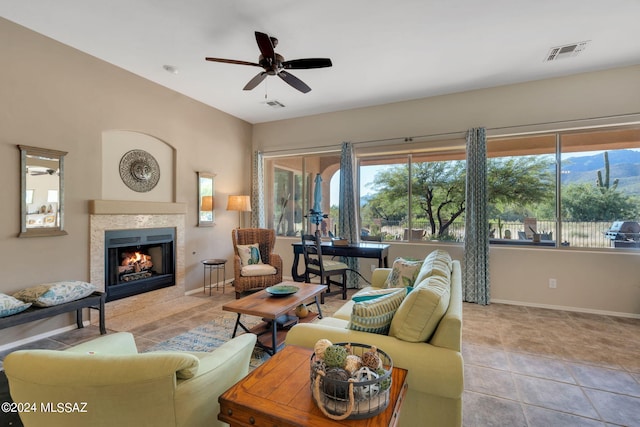 living room featuring ceiling fan, light tile patterned floors, and a tiled fireplace