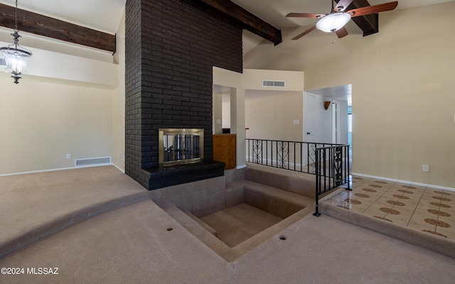 tiled living room featuring a fireplace, beam ceiling, ceiling fan, and a high ceiling