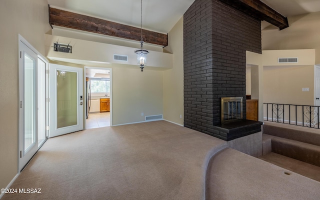 unfurnished living room featuring beam ceiling, a towering ceiling, light colored carpet, and a brick fireplace