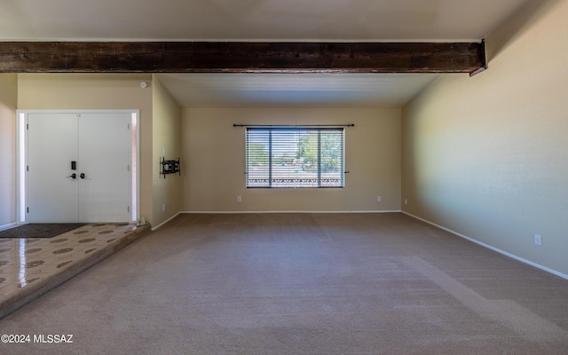 carpeted entryway featuring beam ceiling