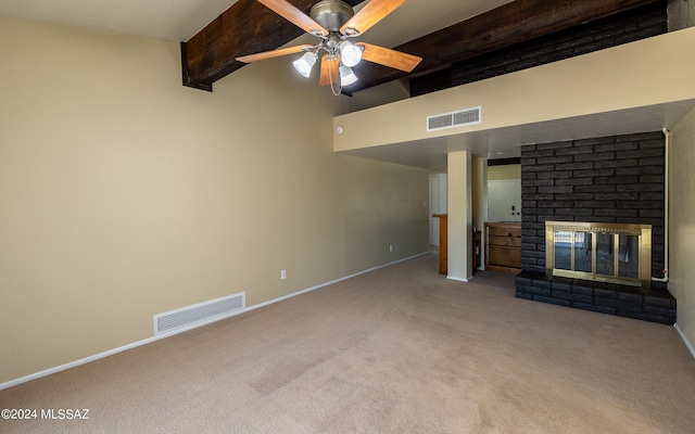 unfurnished living room featuring beam ceiling, ceiling fan, a fireplace, and light colored carpet