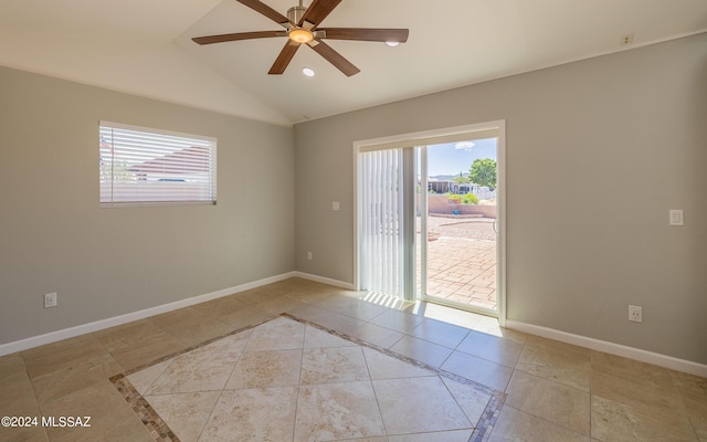 tiled empty room with ceiling fan and vaulted ceiling