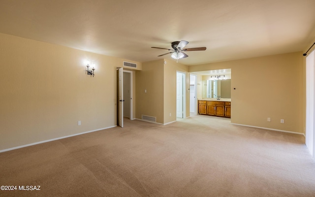 interior space featuring light colored carpet, ceiling fan, and sink