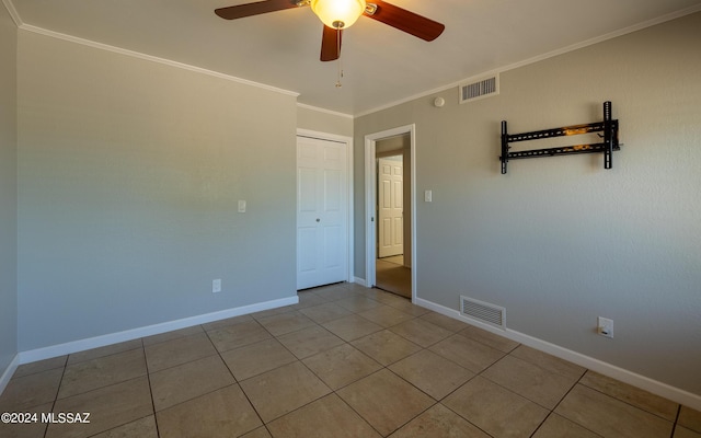 unfurnished room featuring ceiling fan, crown molding, and light tile patterned flooring