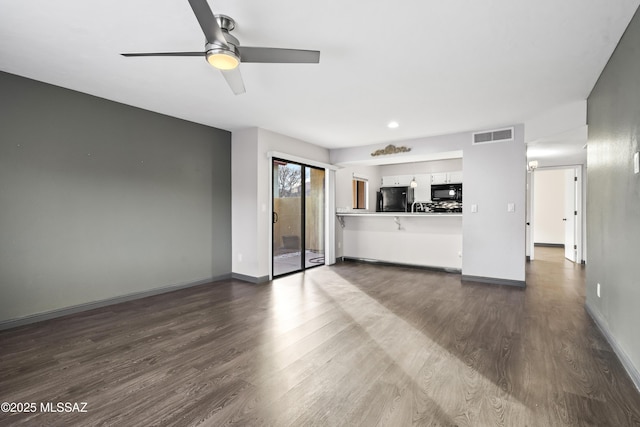 unfurnished living room with ceiling fan and dark wood-type flooring