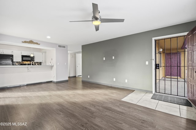 unfurnished living room with light hardwood / wood-style floors and ceiling fan