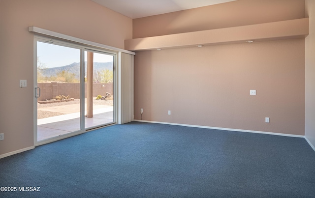 carpeted empty room with baseboards and a mountain view