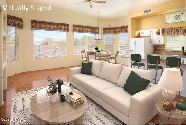 living room with visible vents, baseboards, ceiling fan, and wood finished floors