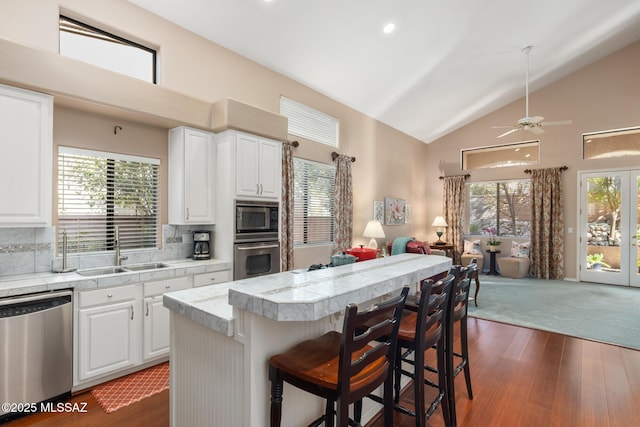 kitchen with backsplash, a center island, white cabinets, and appliances with stainless steel finishes