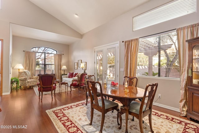 dining room featuring hardwood / wood-style flooring and high vaulted ceiling