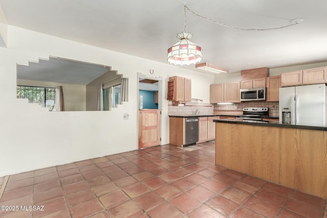 kitchen featuring light brown cabinetry, tasteful backsplash, stainless steel appliances, dark tile patterned floors, and pendant lighting