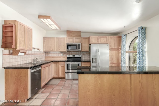 kitchen with kitchen peninsula, light brown cabinetry, and stainless steel appliances