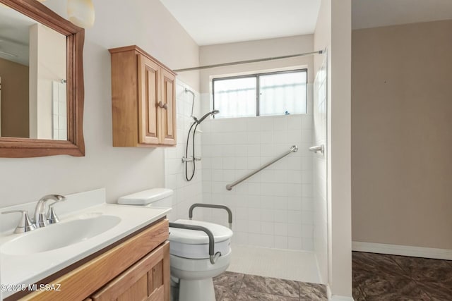 bathroom with tiled shower, tile patterned floors, vanity, and toilet