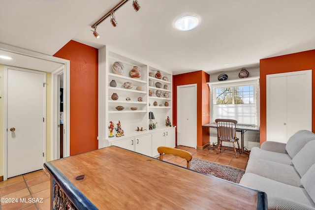 interior space with built in shelves, light tile patterned floors, and rail lighting