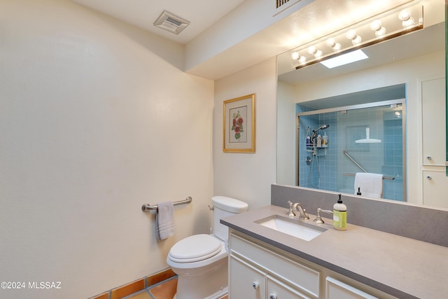 bathroom with tile patterned flooring, vanity, a shower with door, and toilet