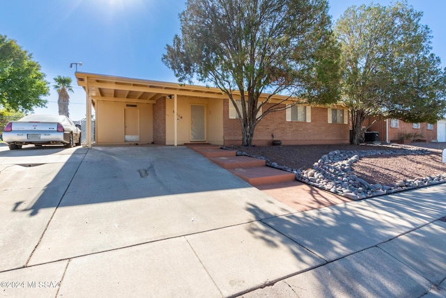 ranch-style house featuring central AC and a carport